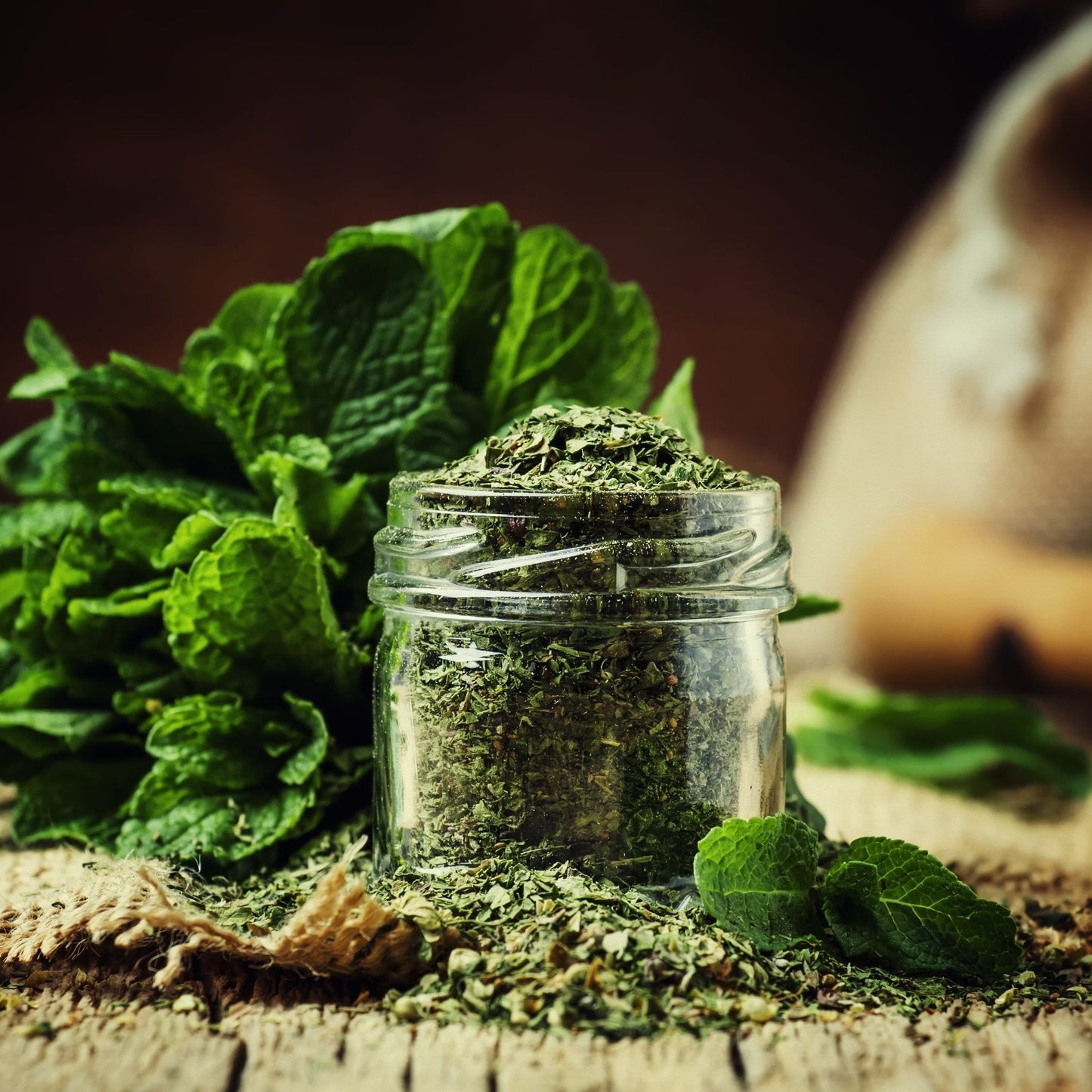 Wild Peppermint Leaf organic dried leaves in glass jar with fresh peppermint on rustic wooden surface