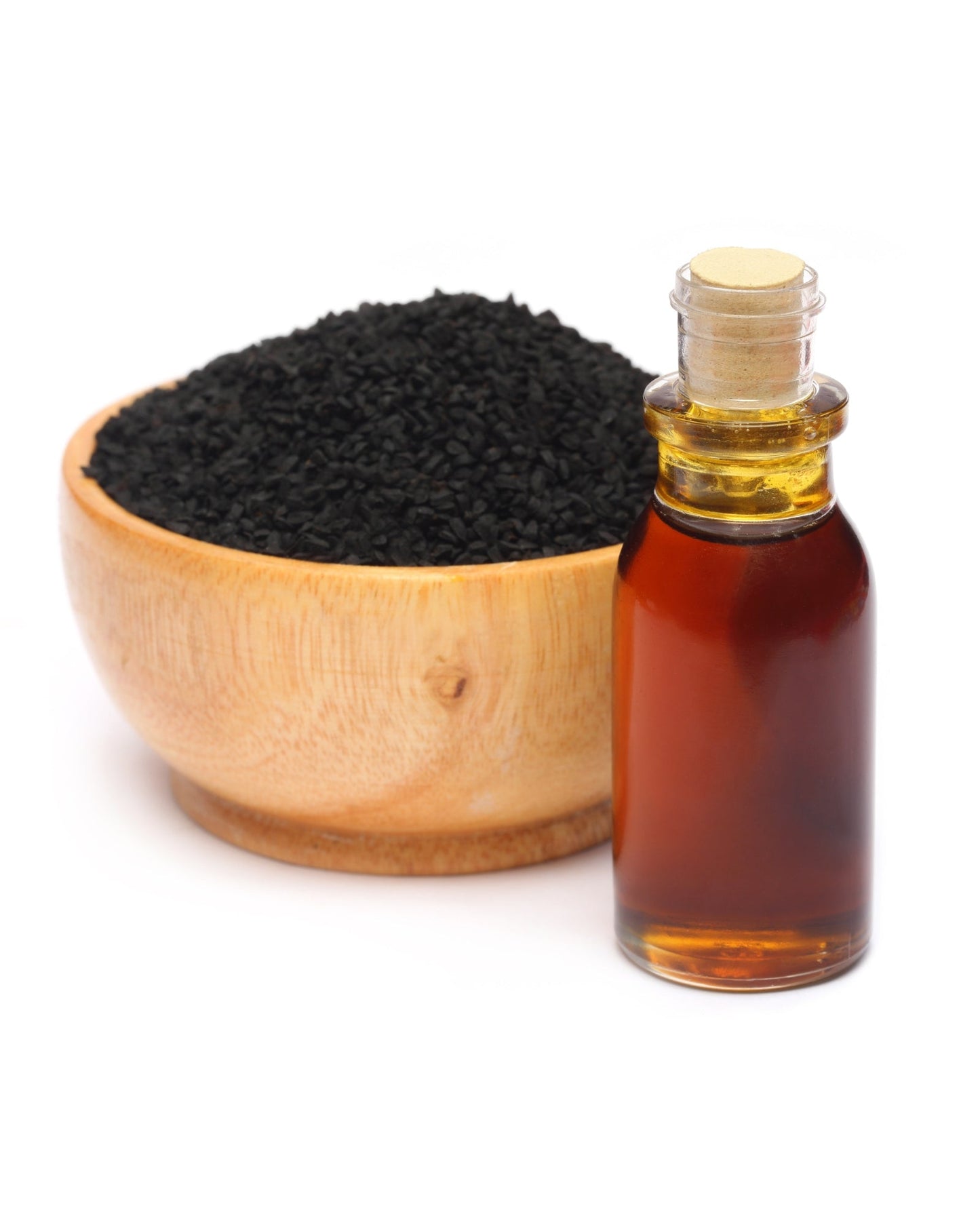 Bottle of pure Ethiopian black seed oil next to a wooden bowl filled with black Nigella sativa seeds